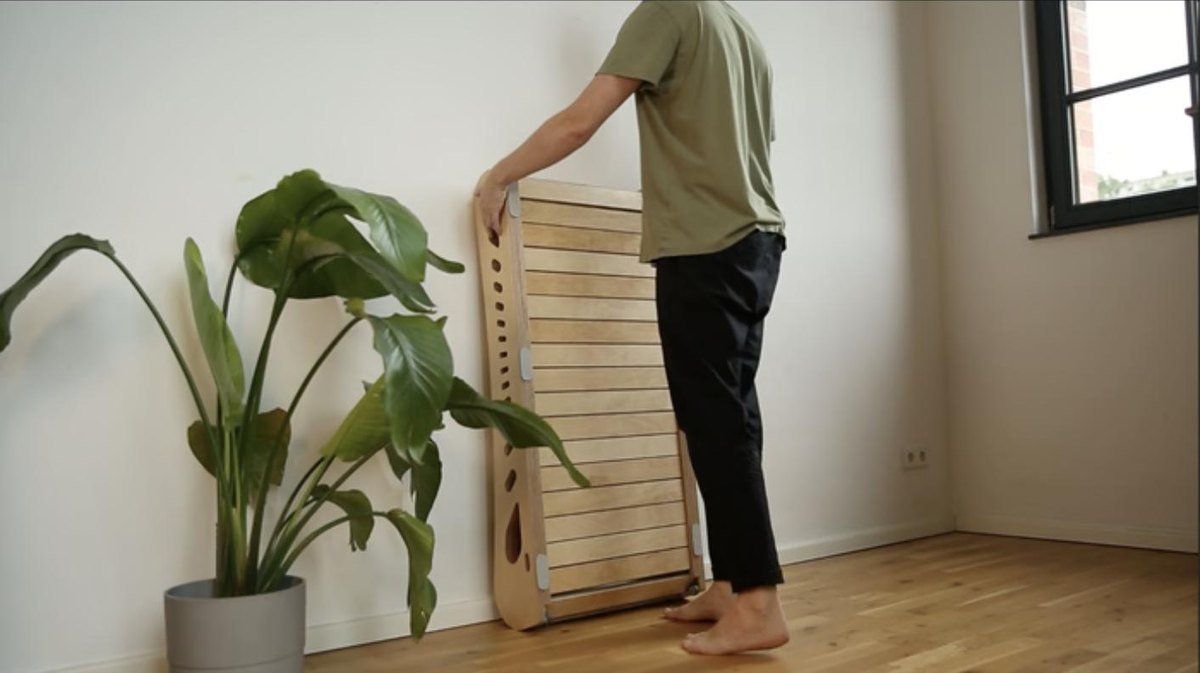 Office Walker parked upright against a wall next to a plant